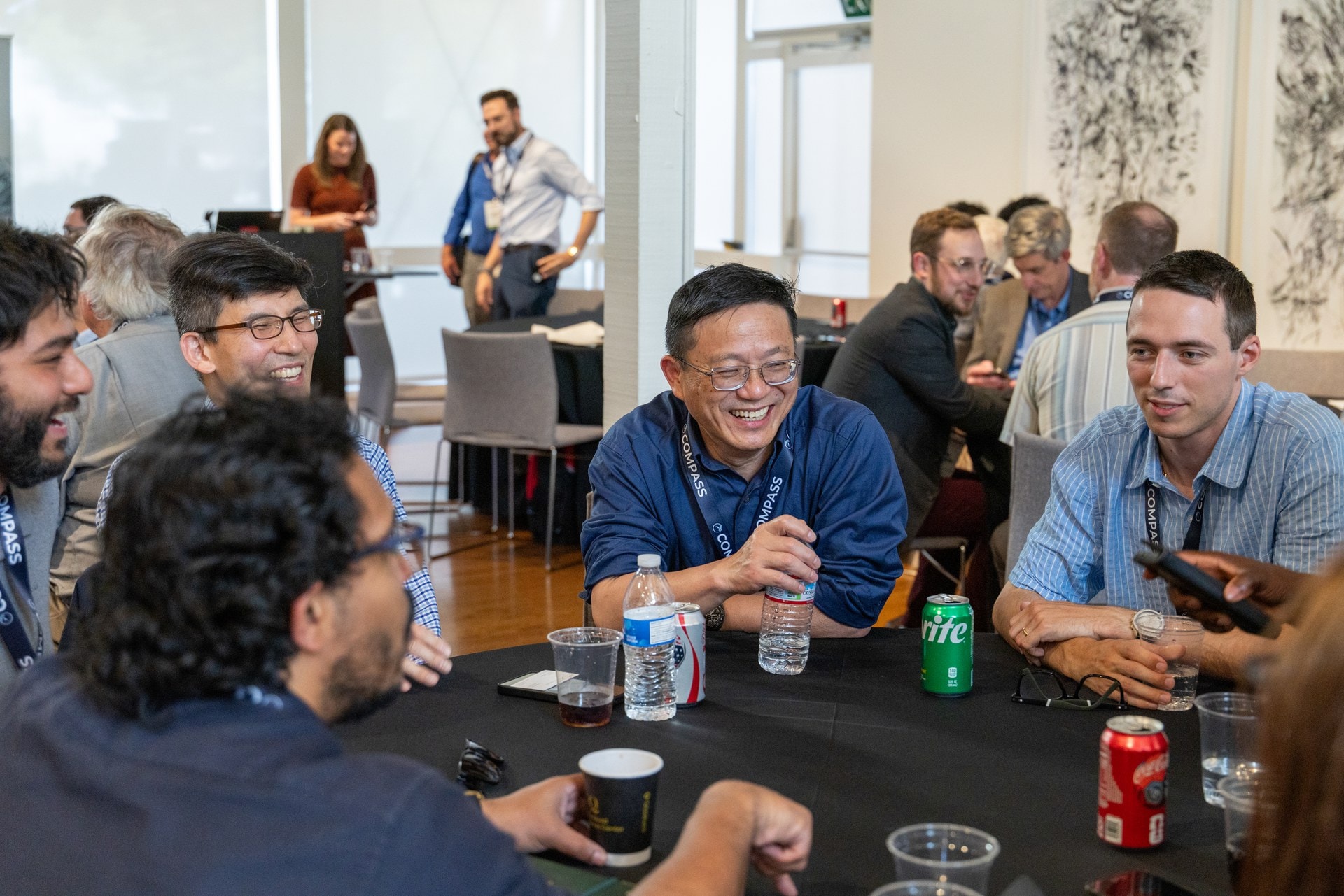Investors and researchers laughing around a table at the Waypoints afternoon program