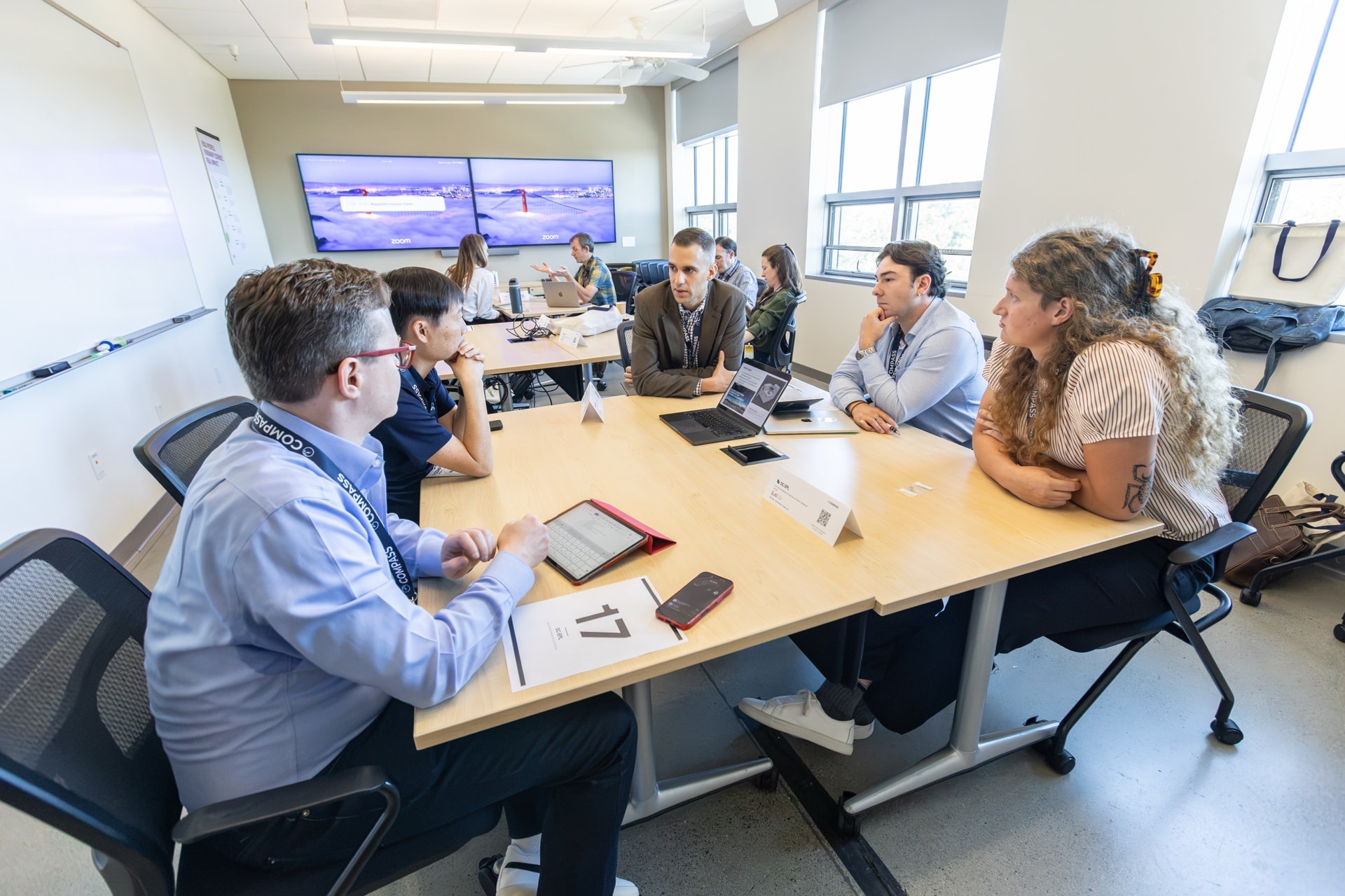 Five attendees in a one-on-one meeting around a table